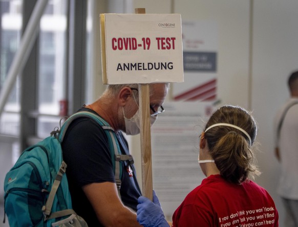 A passengers gets information at the Covid-19 test center at the airport in Frankfurt, Germany, Saturday, Aug. 15, 2020. For passengers coming back from high risk countries Corona tests are mandatory. ...