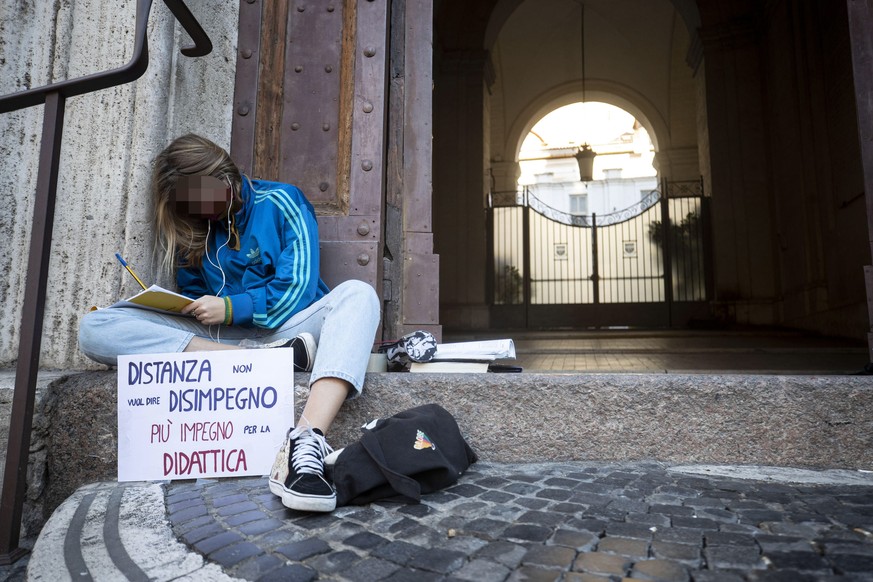 epa08832398 A participant reads a book as students of the Visconti high school stage a sit-in against distance learning, amid the second wave of the Covid-19 coronavirus pandemic, in Rome, Italy, 21 N ...