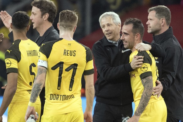 In this Sept. 29, 2018 photo Dortmund coach Lucien Favre, center, hugs Paco Alcacer, right, after Dortmund won 4-2 in the Bundesliga match between Bayer 04 Leverkusen and Borussia Dortmund in Leverkus ...