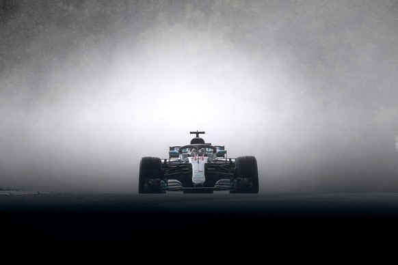epa08435114 British Formula One driver Lewis Hamilton of Mercedes AMG GP leaves a cloud of grey smoke as he speeds during the qualifying session of the Hungarian Formula One Grand Prix at the Hungaror ...