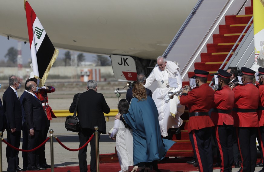 Pope Francis walks down the steps of an airplane as he arrives at Baghdad international airport, Iraq, Friday, March 5, 2021. Pope Francis heads to Iraq to urge the country&#039;s dwindling number of  ...