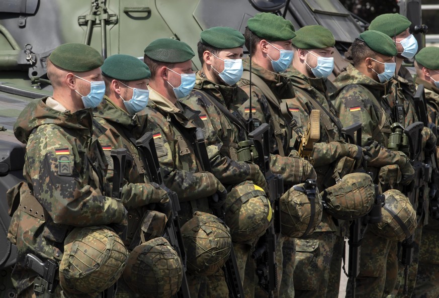 Soldiers of the German Federal Armed Forces Bundeswehr wear face maks as they attend a press presentation showing the battlefield management system (BMS) in the 37th armoured infantry regiment in Fran ...