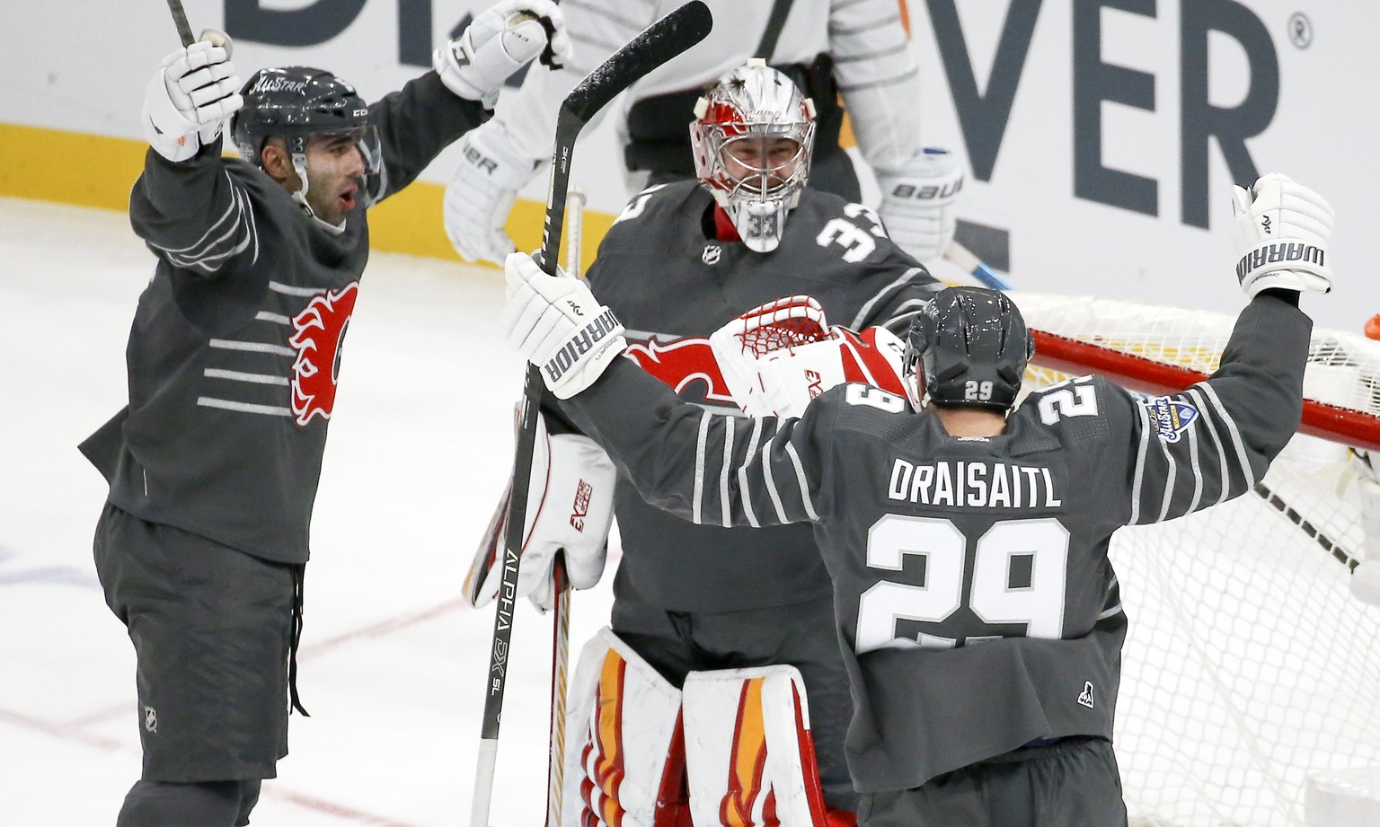 Calgary Flames goalie David Rittich (33) celebrates with Calgary Flames defender Mark Giordano, left, and Edmonton Oilers forward Leon Draisaitl (29) after the Pacific Division defeated the Atlantic D ...