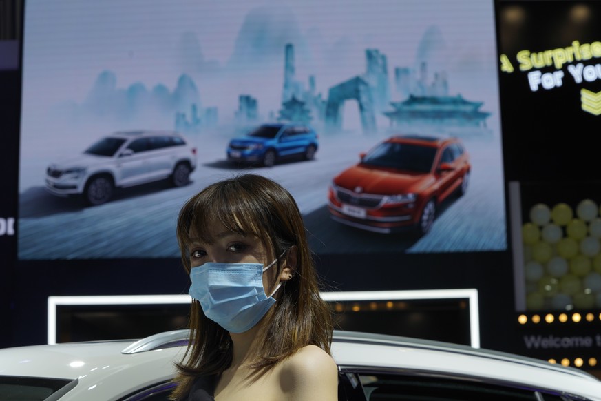 A car model wears a mask to protect from coronavirus, during the Auto China 2020 show in Beijing on Saturday, Sept. 26, 2020. Ford, Nissan and BMW unveiled electric models with more range for China on ...
