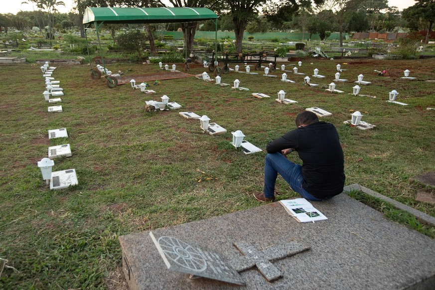 epaselect epa08436515 A man cries for his relative victim of Covid-19 in the Campo de Esperanza cemetery in Brasilia, Brazil, 21 May 2020. Brazil has already registered at least 291,579 cases and arou ...
