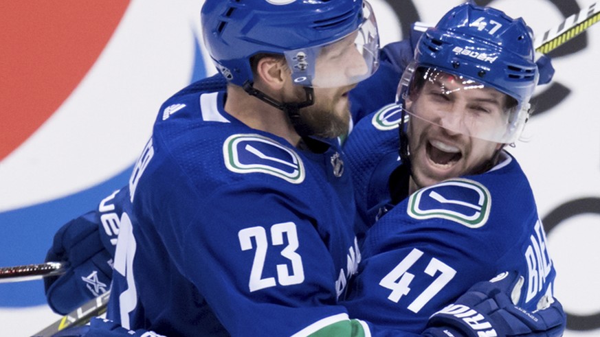 Vancouver Canucks&#039; Alexander Edler (23), of Sweden, and Sven Baertschi (47), of Switzerland, celebrate Baertschi&#039;s goal against the Arizona Coyotes during the second period of an NHL hockey  ...