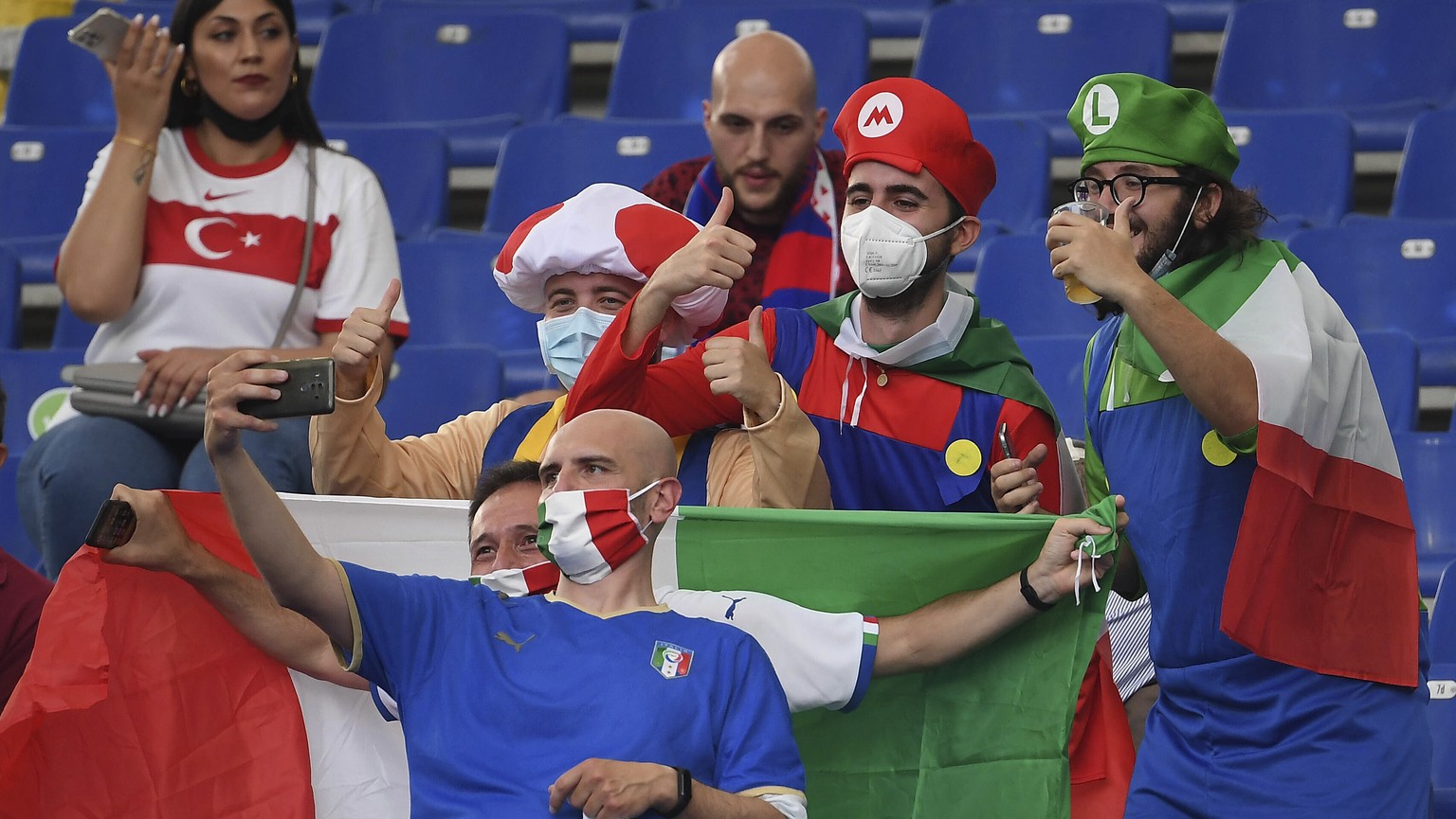 Fans take selfies with their phone before the Euro 2020 soccer championship group A match between Turkey and Italy at the Olympic stadium in Rome, Friday, June 11, 2021. (Ettore Ferrari/Pool via AP)