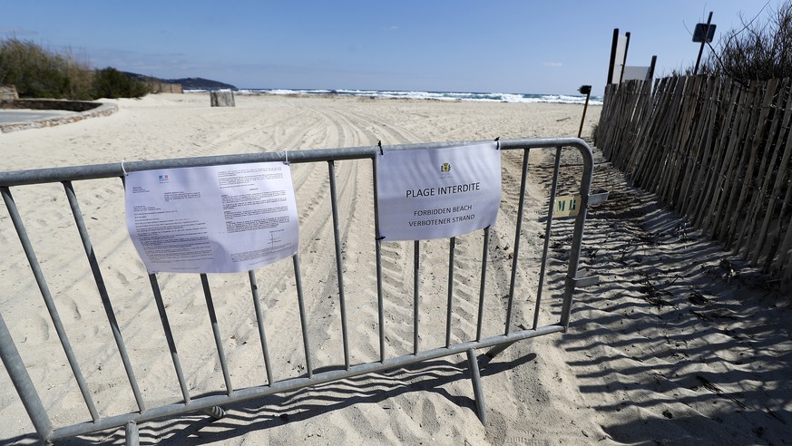 epa08336597 A sign reading &#039;Forbidden beach&#039; hangs on a barrier placed on the beach of Pampelonne in Ramatuelle, southern France, 01 April 2020. France is under lockdown in an attempt to sto ...