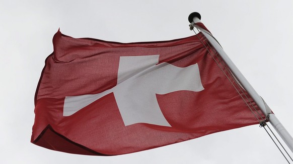 Der Wind fegt durch die Schweiz und strapaziert diese Landesflagge, am Dienstag, 5. Februar 2013, in Tagelswangen, Kanton Zuerich. (KEYSTONE/Steffen Schmidt)