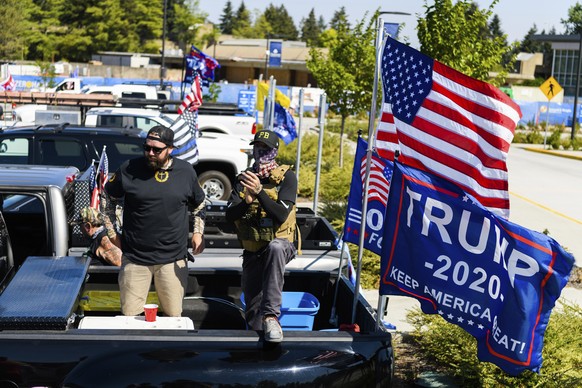 Proud Boy members who chose to remain anonymous listen to Patriot Prayer founder Joey Gibson speak during the &quot;Oregon for Trump 2020 Labor Day Cruise Rally&quot; at Clackamas Community College in ...