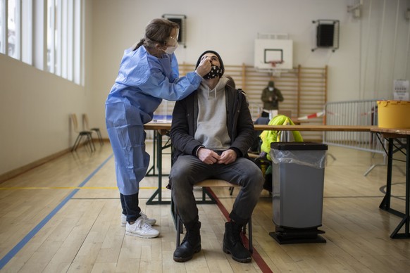 epaselect epa08876669 A man is tested during Covid-19 mass testing, in Zuoz, Switzerland, 11 December 2020. Three regions in the canton of Grisons will be mass tested during three days. The test is vo ...