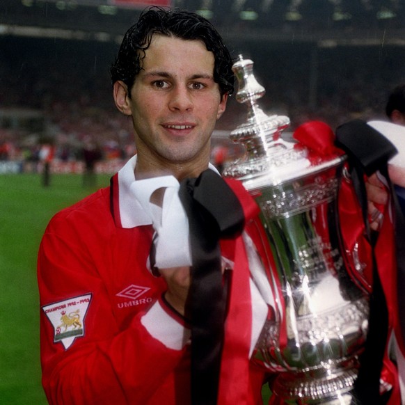 FILE - In this May 1994 file photo, Ryan Giggs of Manchester United holds the FA Cup. Manchester United great Ryan Giggs has ended his playing career after a club-record 963 appearances. Giggs made th ...