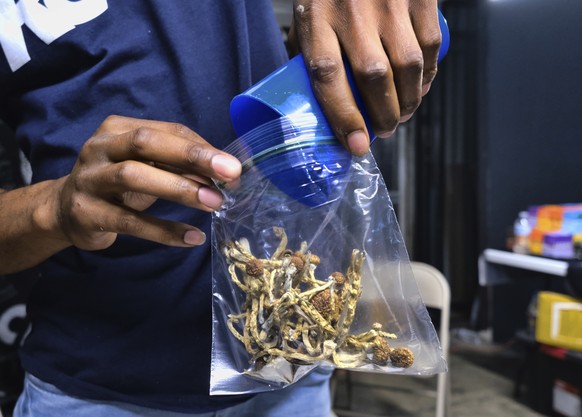 FILE - In this May 24, 2019, file photo a vendor bags psilocybin mushrooms at a pop-up cannabis market in Los Angeles. Voters in Oregon in November 2020 will decide on a measure that would legalize th ...