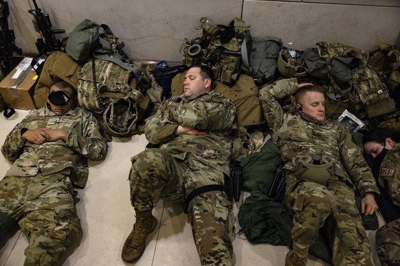 epa08936289 National Guard soldiers rest in the Capitol Visitors Center after being deployed to secure the grounds around the US Capitol building in Washington, DC, USA, 13 January 2021. US President  ...