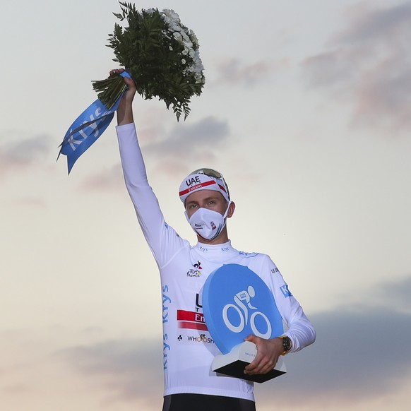 Tour de France winner Slovenia&#039;s Tadej Pogacar, who also won the best young rider&#039;s white jersey, celebrates on the podium after the twenty-first and last stage of the Tour de France cycling ...