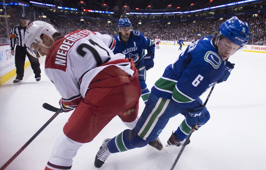 Carolina Hurricanes right wing Nino Niederreiter (21) fights for control of the puck with Vancouver Canucks right wing Brock Boeser (6) during the first period of an NHL hockey game Wednesday, Jan. 23 ...