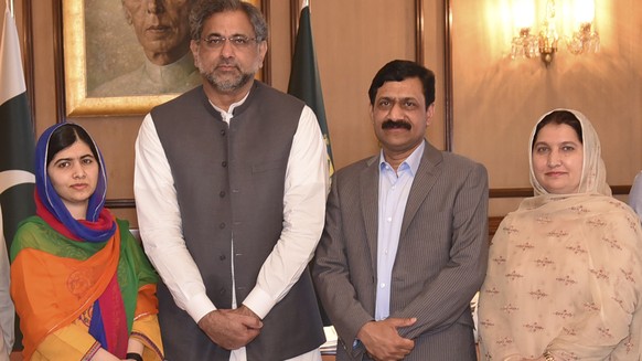 In this photo released by the Press Information Department, Pakistani Nobel Peace Prize winner Malala Yousafzai, left, and her parents pose for a photograph with Shahid Khaqan Abbasi, second from left ...
