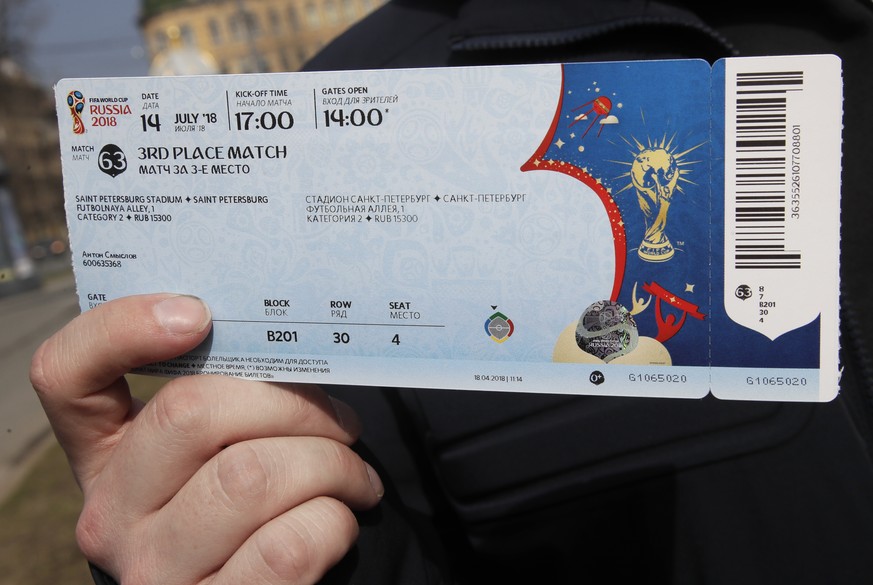 A man holds his ticket for a 2018 World Cup match purchased in a newly opened 2018 World Cup ticketing centre in St. Petersburg, Russia, Wednesday, April 18, 2018. (AP Photo/Dmitri Lovetsky)