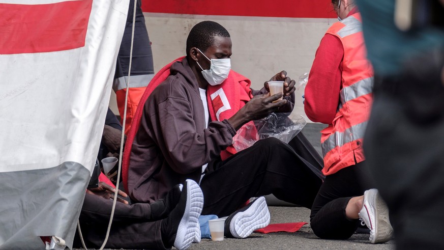 epa08321342 Red cross staff attend to migrants who were rescued at sea in Arguineguin, Gran Canarias, Canary Islands, Spain, 25 March 2020. A total of 37 migrants have been rescued at sea when they we ...