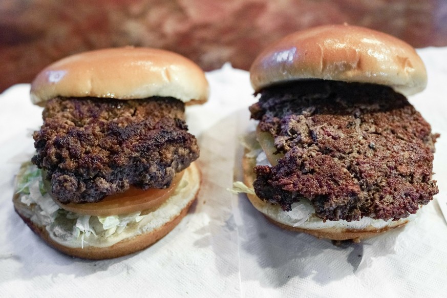 A conventional beef burger, left, is seen Friday, Jan. 11, 2019, next to &quot;The Impossible Burger&quot;, right, a plant-based burger containing wheat protein, coconut oil and potato protein among i ...