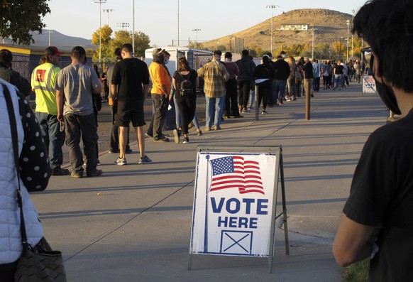 FILE - In this Nov. 3, 2020, file photo, mostly masked northern Nevadans wait to vote in-person at Reed High School in Sparks, Nev., prior to polls closing. U.S. officials say they found no evidence t ...