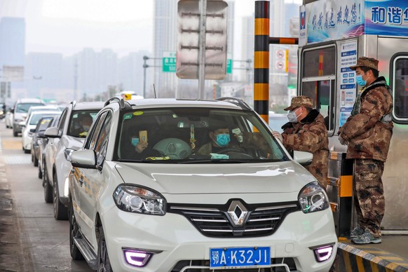 epa08154640 A militia member checks the body temperature of a passenger on a vehicle at an expressway toll gate in Wuhan, central China&#039;s Hubei province, 23 January 2020. Wuhan has shut down publ ...