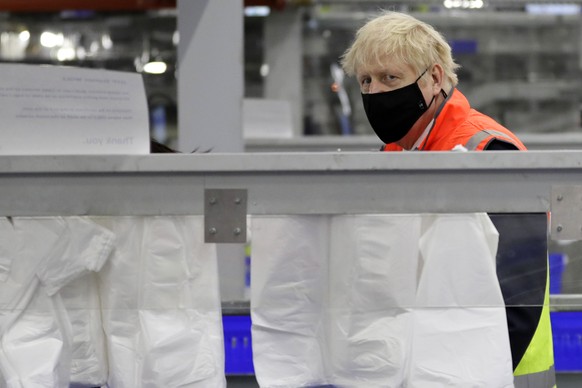 Britain&#039;s Prime Minister Boris Johnson loads produce into baskets during a visit to a tesco.com distribution centre in London, Wednesday, Nov. 11, 2020. (AP Photo/Kirsty Wigglesworth, pool)