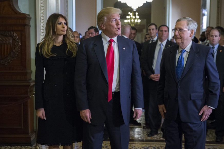 epa05625949 US President elect Donald Trump (C), with his wife Melania Trump (L), and Senate Majority Leader Mitch McConnell (R), responds to a question from the news media after a meeting in the Majo ...