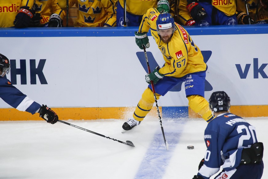Sweden&#039;s Linus Omark, center, controls the puck during the Ice Hockey Channel One Cup match between Finland and Sweden in Moscow, Russia, Saturday, Dec. 17, 2016. (AP Photo/Pavel Golovkin)