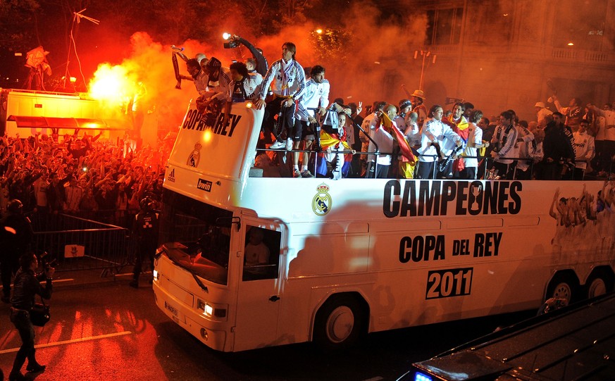 MADRID, SPAIN - APRIL 21: Fans cheer Real Madrid players on an open-top bus upon at Plaza Cibeles on April 21, 2011 in Madrid, Spain. Real beat Barcelona 1-0 in the Copa del Rey final in Valencia&#039 ...