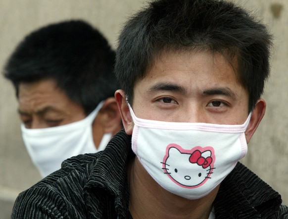 FILE - In this April 23, 2003 file photo, a man wears a Hello Kitty mask in Beijing as the deadly flu-like illness SARS spreads in China. When she came to life in 1974, she was a kitty without a name, ...
