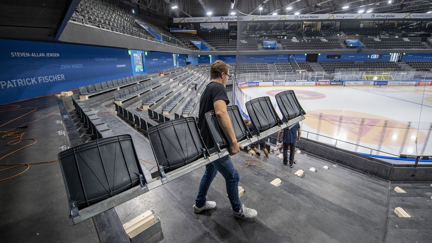 ARCHIV -- START EISHOCKEY SAISON 2020/21 MIT CORONA-SCHUTZMASSNAHMEN --- Im Eishockeystadion Bossard Arena des EV Zug werden in den Stehrampen die neuen Sitzplaetze montiert, dies wegen den Vorsichtsm ...