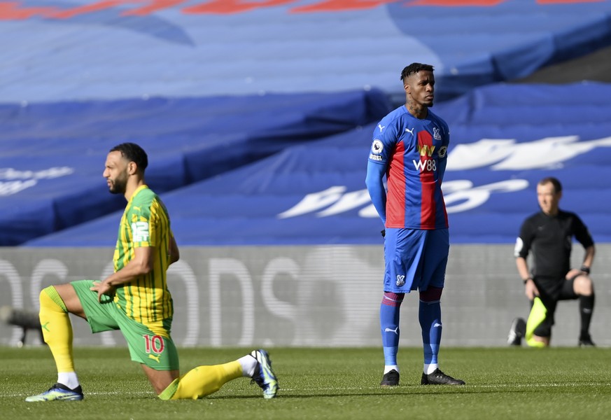 epa09071946 Crystal Palace&#039;s Wilfried Zaha (C) stands as players &#039;take the knee&#039; prior to the match between Crystal Palace and West Bromwich Albion in London, Britain, 13 March 2021. EP ...