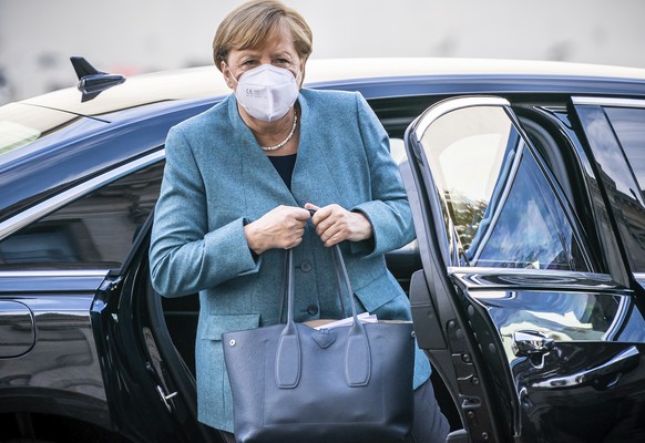 German Chancellor Angela Merkel wears a face mask as she arrives for the meeting of the CDU/CSU parliamentary group at the Reichstag building, home of the German federal parliament, in Berlin, Germany ...
