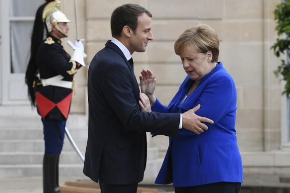 epa06084151 German Chancellor Angela Merkel (R) is welcomed by French President Emmanuel Macron upon her arrival at the Elysee Palace in Paris, France, 13 July 2017. EPA/JULIEN DE ROSA