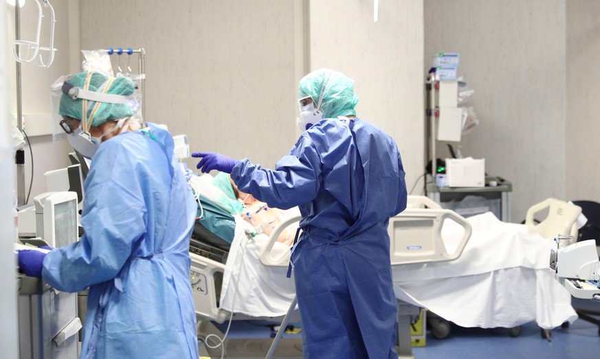 epa08306809 Healthcare personnel wearing protective suits and mask at work in the intensive care unit of the Brescia&#039;s Hospital, Italy, 19 March 2020. Italy has reported at least 35,713 confirmed ...