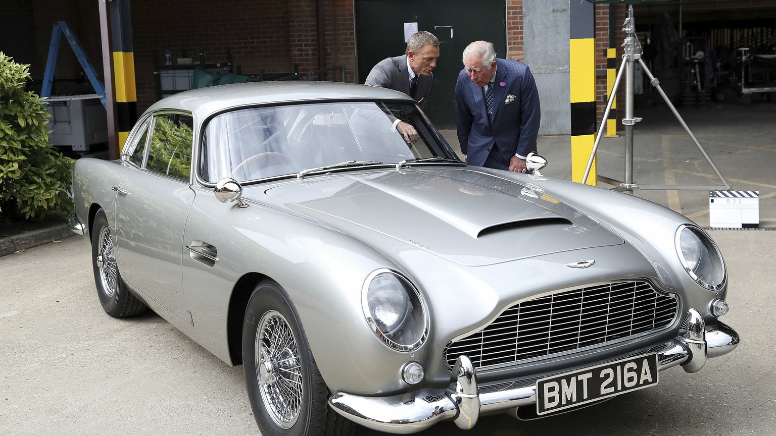 Britain&#039;s Prince Charles talks with actor Daniel Craig, left, as they view the Aston Martin DB5 Bond car during a visit to the set of the 25th James Bond film at Pinewood Studios in Iver Heath, s ...