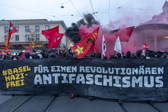 Demonstranten halten Transparente und zuenden Petarden an der Kundgebung Basel Nazifrei in Basel, am Samstag, 28. November 2020. (KEYSTONE/Georgios Kefalas)