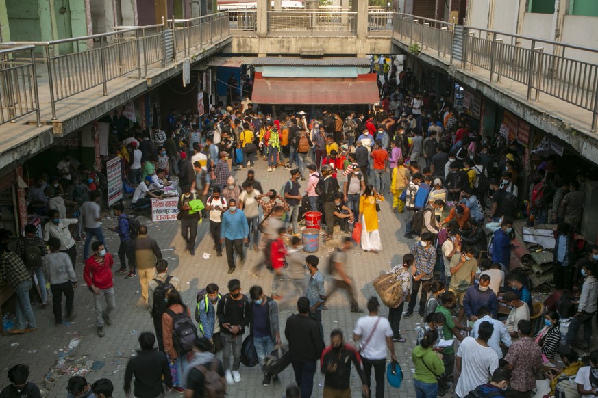 Nepalese people arrive at a crowded bus station to buy bus tickets to go back to their villages a day prior to lockdown in Kathmandu, Nepal, Wednesday, April 28, 2021. Tens of thousands of people left ...