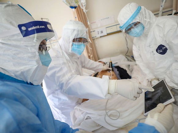 Medizinisches Personal in einem Spital in der chinesischen Stadt Wuhan überprüft den Zustand eines Patienten, der mit dem neuartigen Coronavirus infiziert ist.