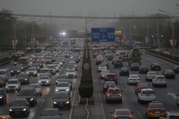 epa09136773 Vehicles drive on a main road as the area is hit by sandstorm, in Beijing, China, 15 April 2021. EPA/WU HONG