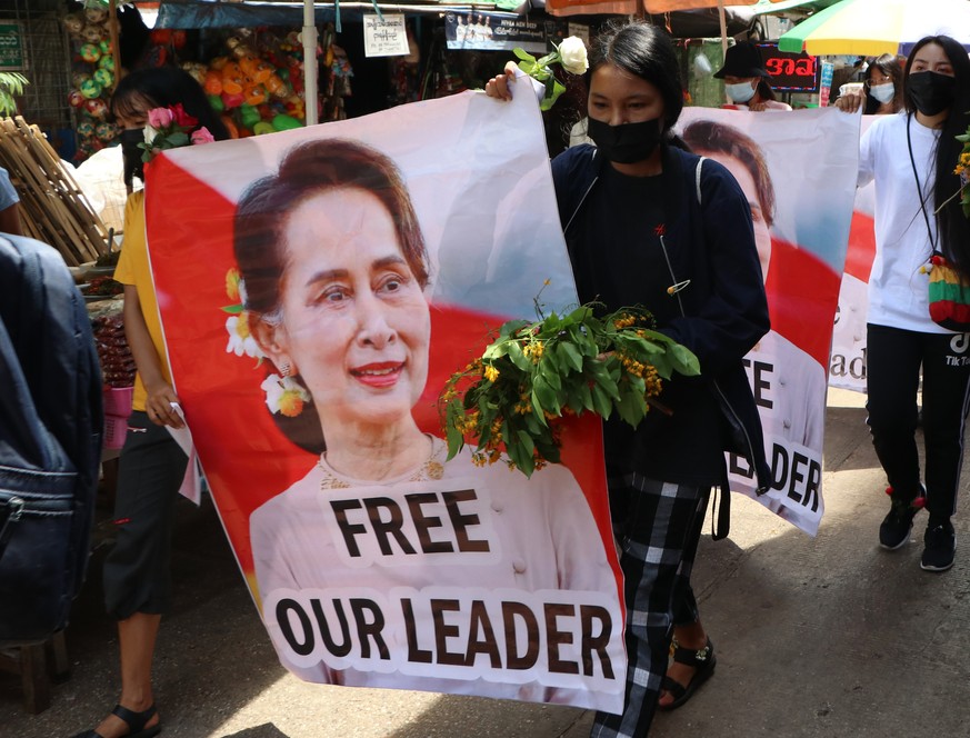 Anti-coup protesters walk through a market with images of ousted Myanmar leader Aung San Suu Kyi at Kamayut township in Yangon, Myanmar Thursday, April 8, 2021. They walked through the markets and str ...