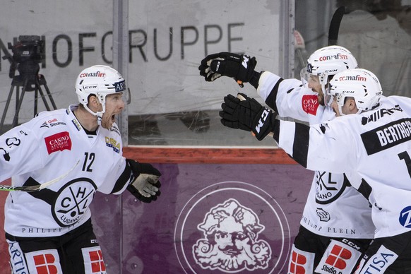 Luganos Dominic Lammer, Raphael Herburger und Alessio Bertaggia, von links, feiern den Treffer zum 0-1 im Eishockey Meisterschaftsspiel der National League zwischen dem SC Bern und dem HC Lugano, am S ...
