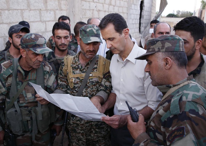 In this photo released on Sunday, June 26, 2016, by the Syrian official news agency SANA, Syrian President Bashar Assad, second right, speaks with Syrian troops during his visit to the front line in t ...