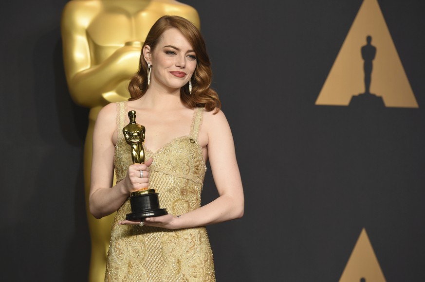Emma Stone poses in the press room with the award for best actress in a leading role for &quot;La La Land&quot; at the Oscars on Sunday, Feb. 26, 2017, at the Dolby Theatre in Los Angeles. (Photo by J ...