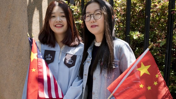 Chen Chen Huang, left, and friend Di Wang hold American and Chinese flags after Huang graduated from Columbia University&#039;s School of Engineering and Applied Science, Wednesday, May 22, 2019 in Ne ...