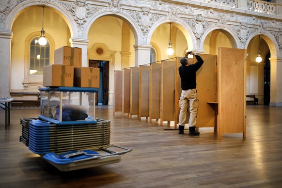 A worker prepares voting booths at a polling station in Lyon, central France, Saturday, April 22, 2017. The two-round presidential election will take place on April 23 and May 7. (AP Photo/Laurent Cip ...