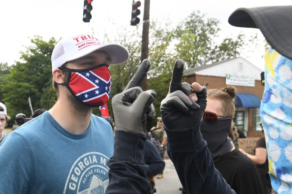 epa08605658 Far-right groups, including militias and white supremacists face conter demonstrators during a rally in Stone Mountain, Georgia, USA, 15 August 2020. The rally was suppopsed to be held at  ...