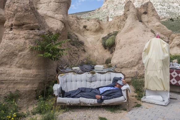 TURKEY, Cappadocia, Goreme. Local souvenir seller rests during the day on the coach in Cappadocia, which is a location on the central Anatolia plateau within a volcanic landscape sculpted by erosion t ...