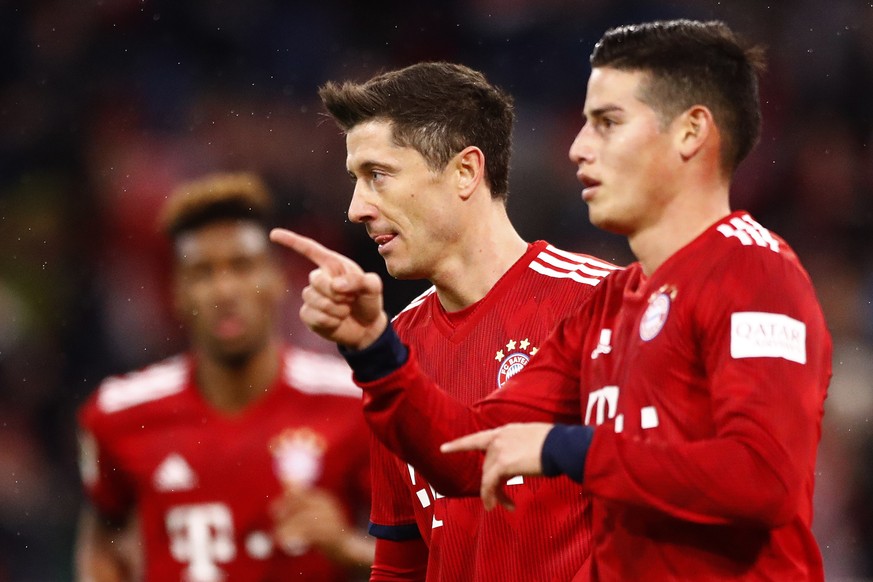Bayern&#039;s Robert Lewandowski, center, celebrates with team mate James, right, and Kingsley Coman, background, after scoring during the German Bundesliga soccer match between FC Bayern Munich and 1 ...